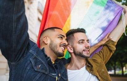 gay couple smiling with pride flag